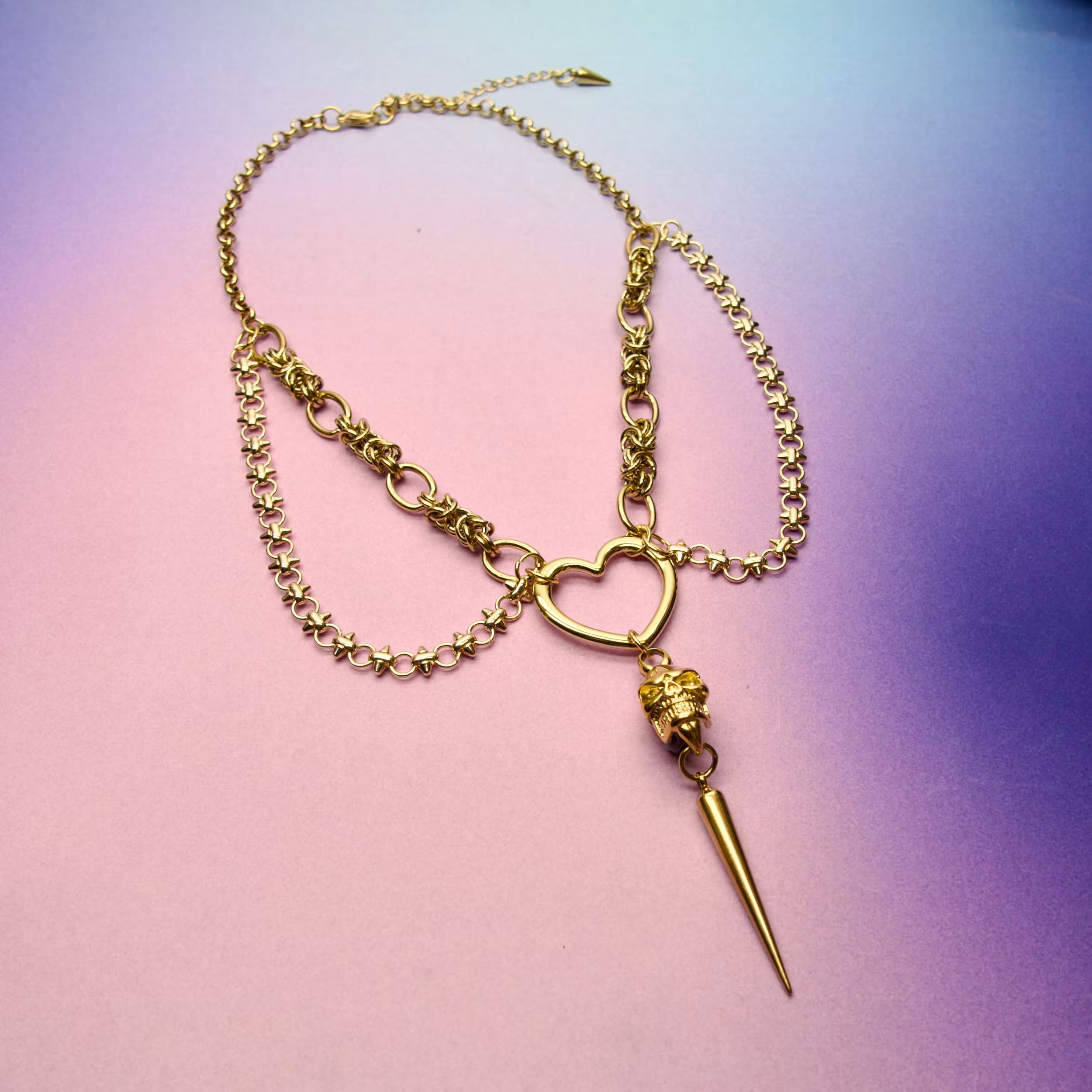 Gothic gold necklace with skull charm, heart centrepiece, and adjustable stainless steel chains.