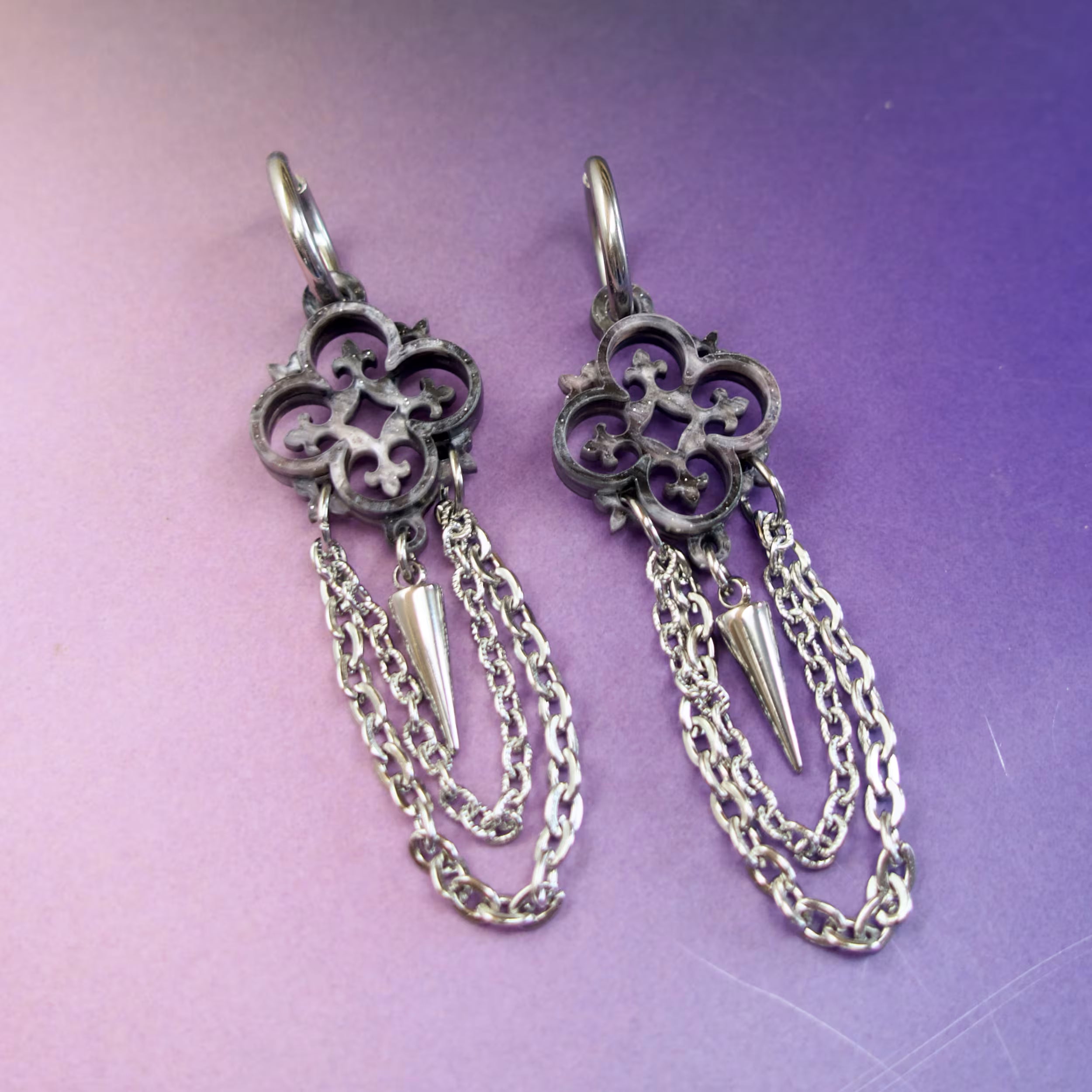 Medieval-inspired statement earrings in grey silver marbled acrylic with chain and spike details — gothic fashion accessories