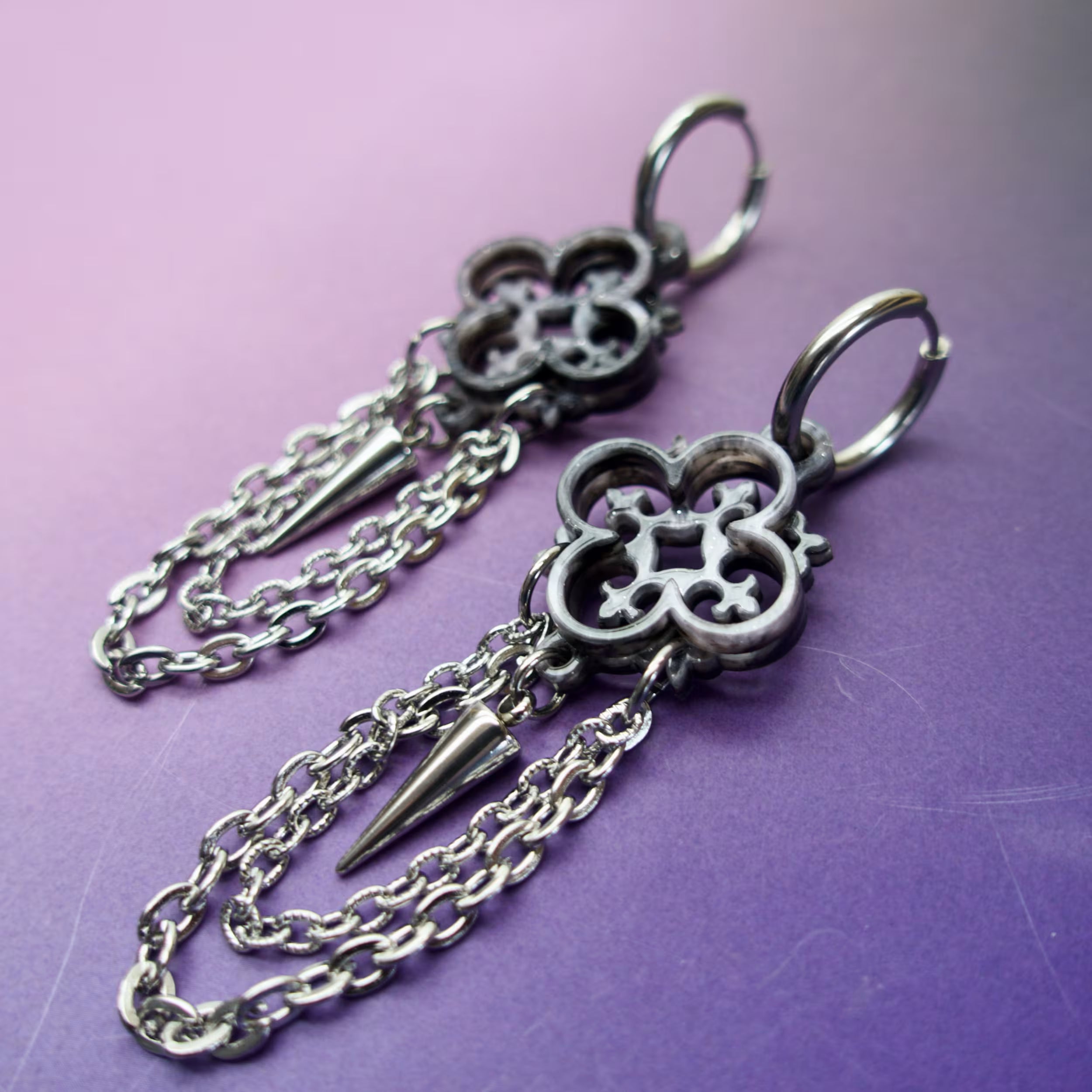 Architectural gothic earrings featuring silver marbled quatrefoil design and steel chains — lightweight alternative jewelry