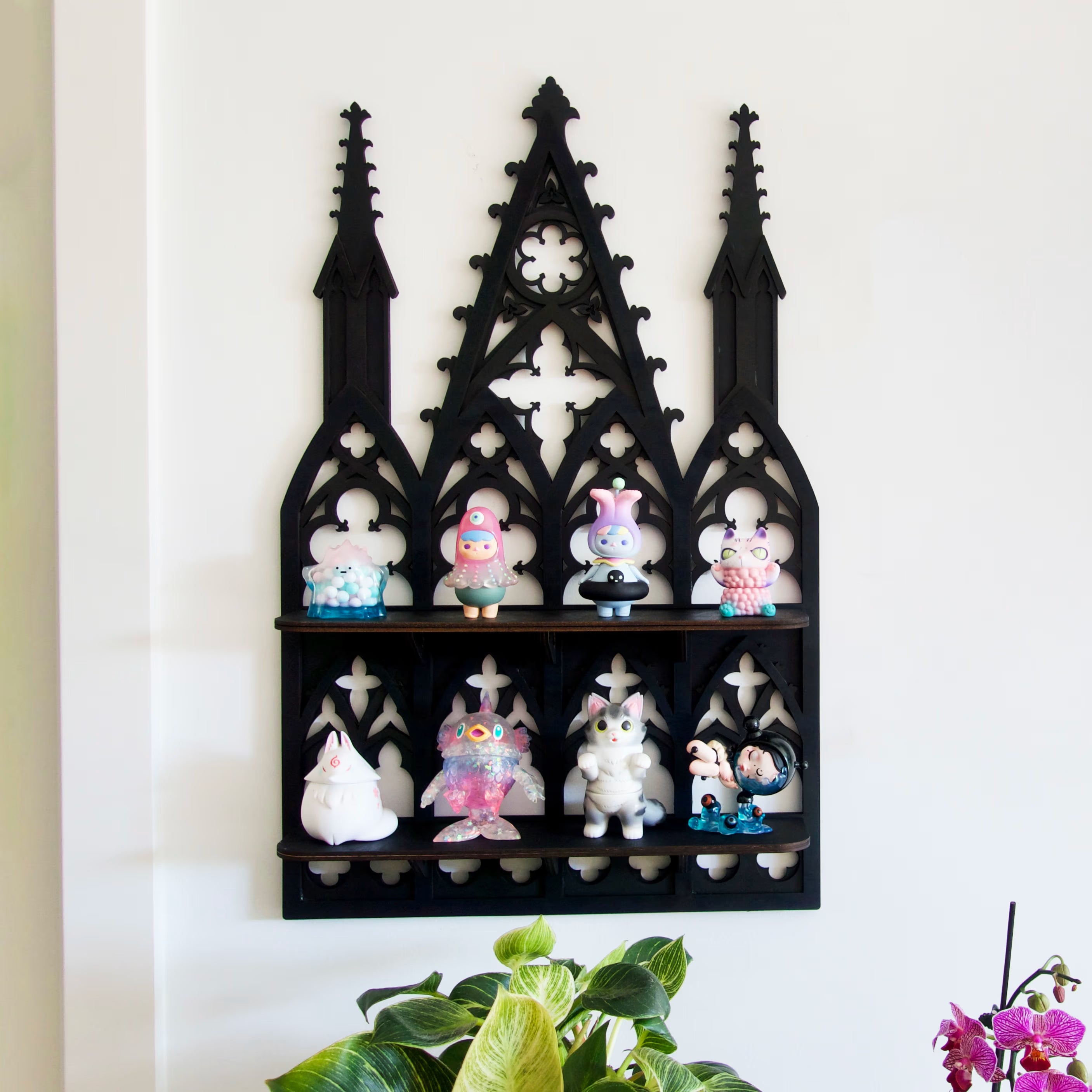 Gothic cathedral wall shelf holding art toys and curios — dark romantic home decor in black hand-inked plywood.