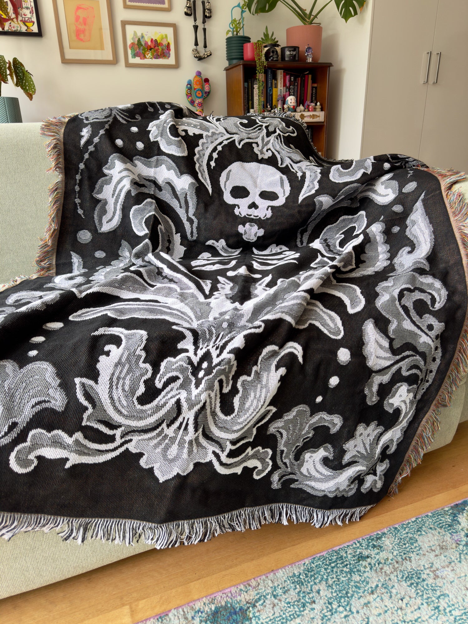 Black and white patterned blanket draped over a couch in a living room.