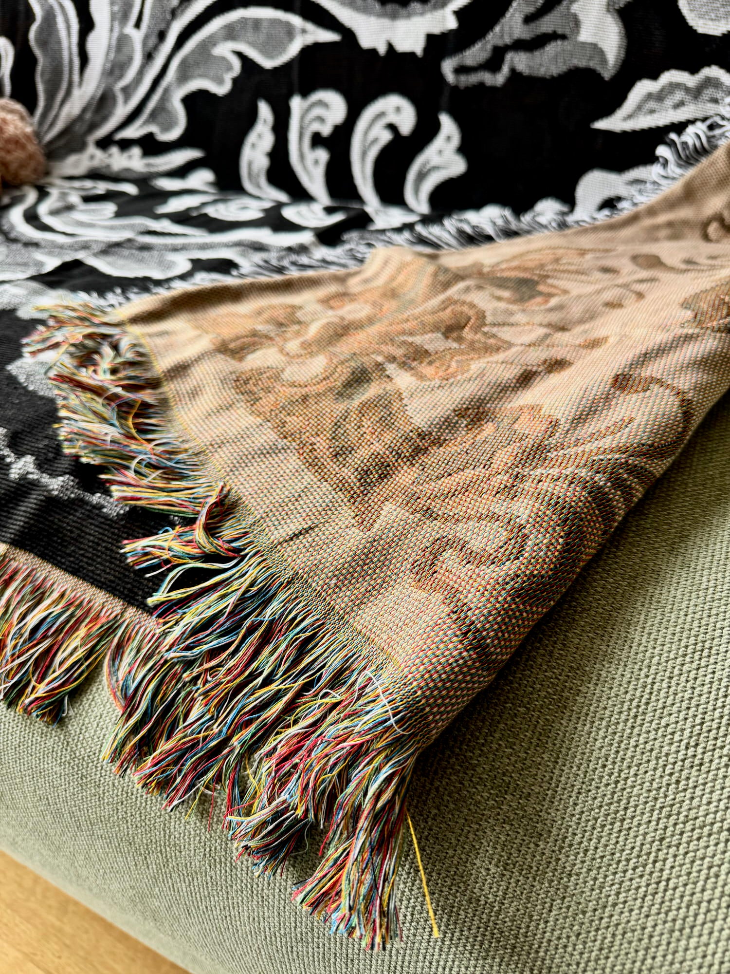 Patterned blanket with fringes on a green surface